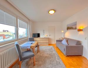 a living room with a couch and a table at Haus Iderhoff- Wohnung 5 in Norderney