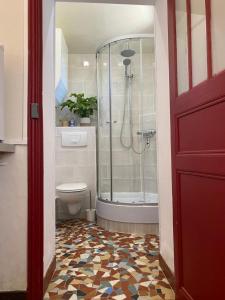 a bathroom with a shower and a toilet and a red door at Château La Barge - Dordogne in La Boissière-dʼAns