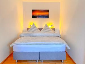 a bed with white pillows in a bedroom at Haus Iderhoff- Wohnung 5 in Norderney +7 photos