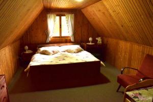 a bedroom with a bed in a wooden room at Chata Doubice in Doubice