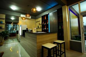 een keuken met een bar met 2 krukken bij Patt Serviced Apartments in Chon Buri