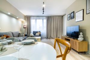 een woonkamer met een witte tafel en een tv bij ApartamentySnu, Słoneczny Standard z parkingiem, Centrum in Radom +7 foto's