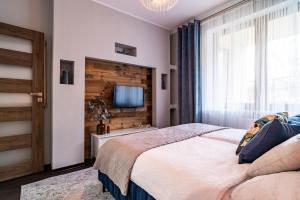 a bedroom with a bed and a tv on a wall at ApartamentySnu, Słoneczny Standard z parkingiem, Centrum in Radom