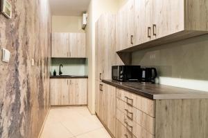 a kitchen with wooden cabinets and a microwave at ApartamentySnu, Słoneczny Standard z parkingiem, Centrum in Radom