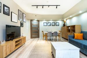 een woonkamer met een blauwe bank en een tafel bij ApartamentySnu, Słoneczny Standard z parkingiem, Centrum in Radom