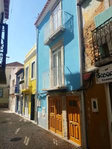 un bâtiment bleu avec des portes orange dans une rue dans l'établissement Lovely Loft, à Setúbal