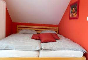 1 dormitorio con 2 camas y paredes de color rojo en Hiška pod gradom, en Celje