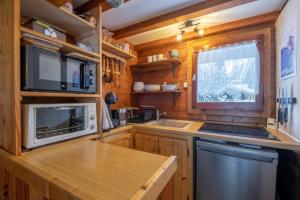 a kitchen with wooden cabinets and a sink and a microwave at Le Mazot - mezzanine with nice view in Chamonix-Mont-Blanc