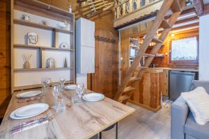 - une salle à manger avec une table en bois dans une petite maison dans l'établissement Le Mazot - mezzanine with nice view, à Chamonix-Mont-Blanc