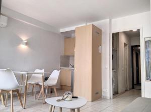 Habitación con mesa, sillas y cocina. en Résidence Graziella Studio 502, en Juan-les-Pins