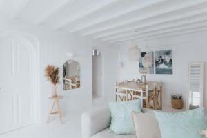 a white living room with a white couch and a table at myMykonos Villa I in Platis Gialos