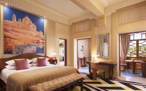a bedroom with a bed and a large painting on the wall at Umaid Bhawan Palace Jodhpur in Jodhpur