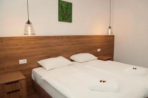 a bedroom with a white bed with two pillows at Varo&scaron; Čar&scaron;ija in Trebinje