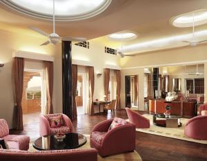 a living room with pink chairs and a ceiling at Umaid Bhawan Palace Jodhpur in Jodhpur
