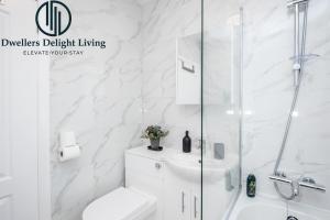 a white bathroom with a shower and a toilet at Dwellers Delight Living Ltd Serviced Accommodation Fabulous House 3 Bedroom, Hainault Prime Location ,Greater London with Parking & Wifi, 2 bathroom, Garden in Chigwell