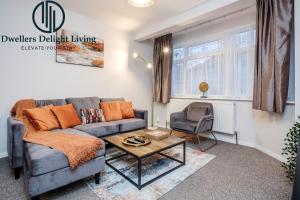 uma sala de estar com um sofá e uma cadeira em Dwellers Delight Living Ltd Serviced Accommodation Fabulous House 3 Bedroom, Hainault Prime Location ,Greater London with Parking & Wifi, 2 bathroom, Garden em Chigwell