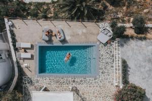 eine Aussicht auf Personen, die im Pool schwimmen in der Unterkunft myMykonos Villa I in Platis Gialos