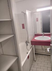La salle de bains est pourvue d'un lavabo, d'une baignoire et d'un porte-parole. dans l'établissement Résidence Graziella Studio 305, à Juan-les-Pins