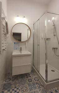 a bathroom with a shower and a sink and a mirror at Holiday Home Aparthotel 009 in Międzyzdroje