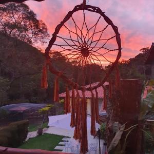 a ferris wheel in a garden at sunset at Pousada do Coura in Pouso Alto