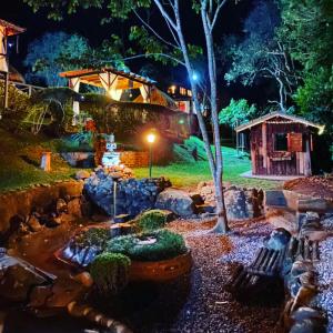 a garden at night with a pond and rocks at Pousada do Coura in Pouso Alto
