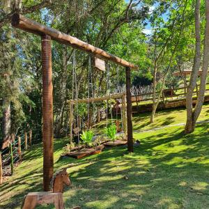 a garden with a wooden structure in the grass at Pousada do Coura in Pouso Alto
