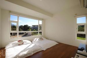 1 dormitorio con 2 camas blancas y 2 ventanas en redhouse en Puli