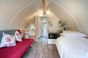 a bedroom with two beds and a red couch at Finest Retreats - Humbleton Glamping in Hexham