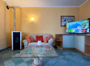 a living room with a couch and a flat screen tv at Villetta a schiera con giardino - Val Trebbia 