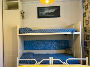 a bunk bed in a room with blue sheets at Villetta a schiera con giardino - Val Trebbia 