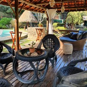 a patio with chairs and a table on a deck at Pousada do Coura in Pouso Alto