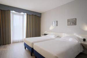 una camera d'albergo con due letti e una finestra di Hotel Viest a Vicenza