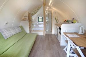 une petite chambre avec un canapé vert dans une petite maison dans l'établissement Finest Retreats - The Wonneys Glamping, à Hexham