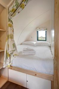 Ce lit se trouve dans une petite chambre dotée d'une fenêtre. dans l'établissement Finest Retreats - The Wonneys Glamping, à Hexham