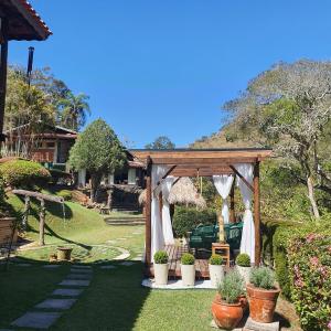 a gazebo with potted plants in a yard at Pousada do Coura in Pouso Alto