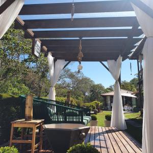 a wooden deck with a blue and white pergola at Pousada do Coura in Pouso Alto