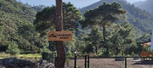 a sign on a tree with a mountain in the background at Lalin Suit Apart Bungalow in Kumluca