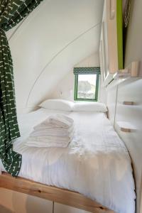 Finest Retreats - Barebones Glamping في هيكسهام: غرفة بسرير وملاءات بيضاء ونافذة