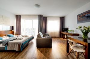 サルビノボにあるAtrium Apartamentyのベッドルーム1室(ベッド1台、デスク、椅子付)