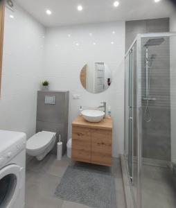 a bathroom with a toilet and a sink and a shower at Welcome Apartment in Suwałki