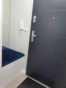 a locker room with a blue bench and a phone at Welcome Apartment in Suwałki
