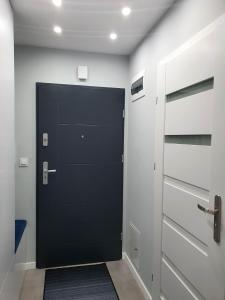 a black door in a room with a hallway at Welcome Apartment in Suwałki