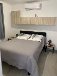 a bedroom with a bed with a white comforter at Résidence Pasturella in Bastia