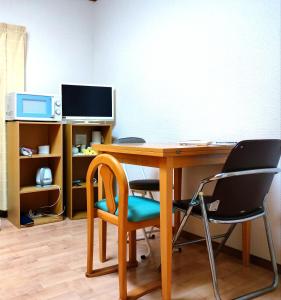 an office with a desk with chairs and a computer at 大宮溫馨小屋 in Saitama