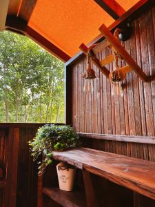 eine Holzterrasse mit einer Bank und einem Fenster in der Unterkunft Freedolina Glamping in Łowyń