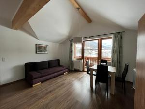 ein Wohnzimmer mit einem Sofa und einem Tisch in der Unterkunft Wurznwirt in Schneizlreuth
