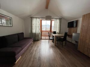 ein Wohnzimmer mit einem Sofa und einem Tisch in der Unterkunft Wurznwirt in Schneizlreuth