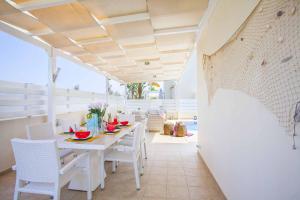 Villa Posidonas Three في بروتاراس: غرفة طعام بيضاء مع طاولة وكراسي