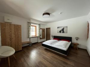um quarto com uma cama e uma cadeira em Wurznwirt em Schneizlreuth