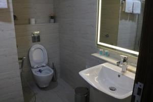 une salle de bain avec toilettes, lavabo et miroir dans l'établissement فندق منار بارك, à Riyad 34 autres photos